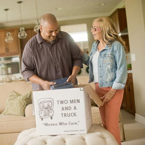 couple packing up items into a two men and a truck branded box