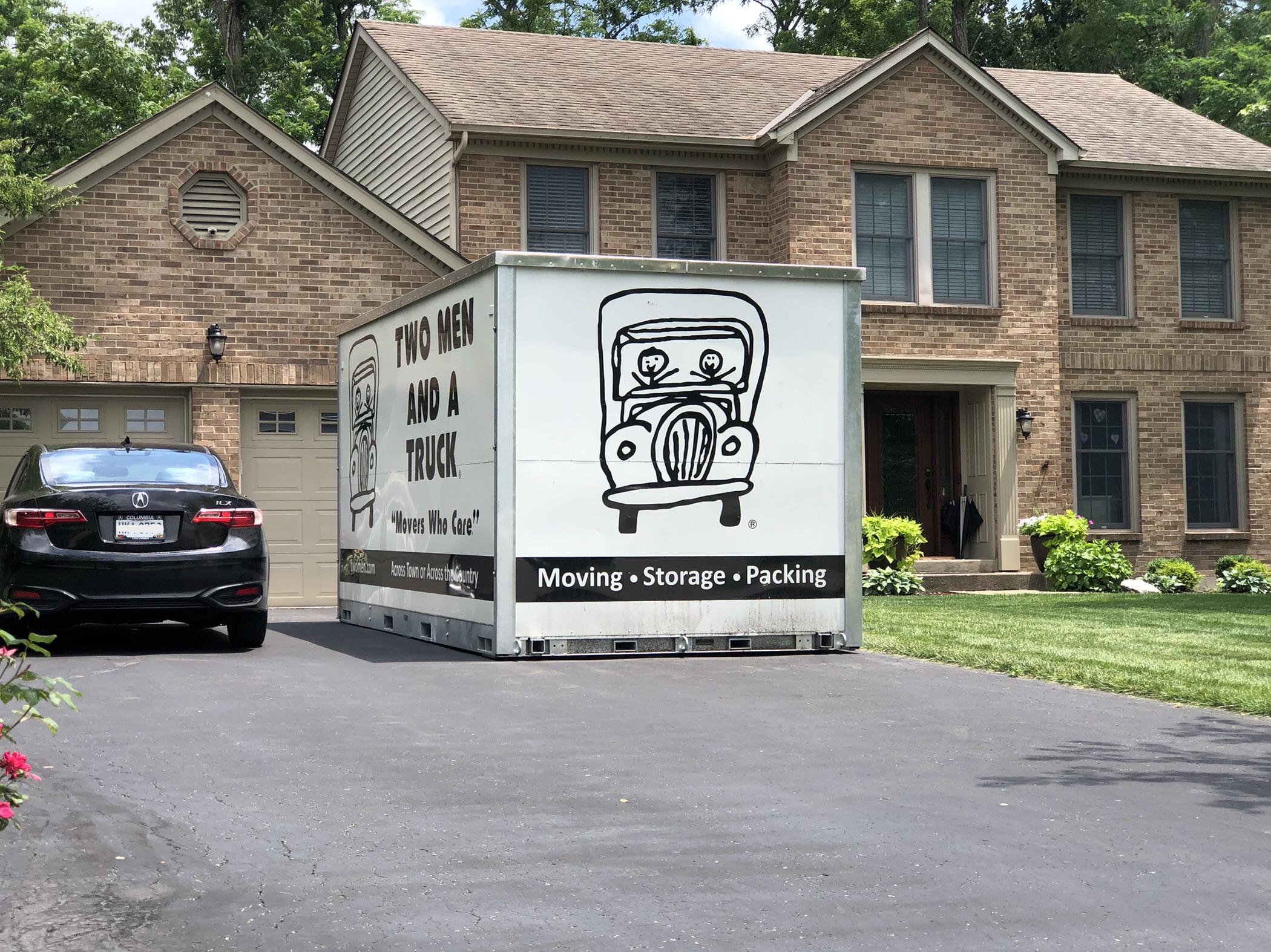 temporary storage container in driveway of brick home