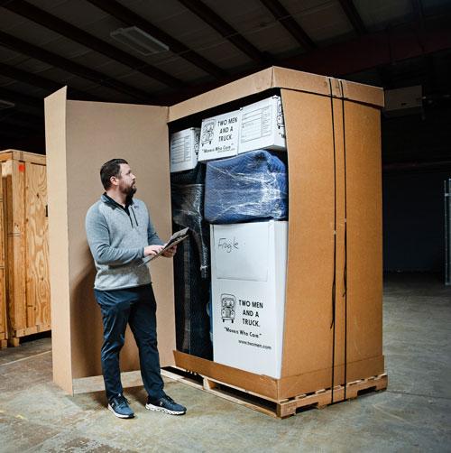 A manager checking inventory in a crate of belongings