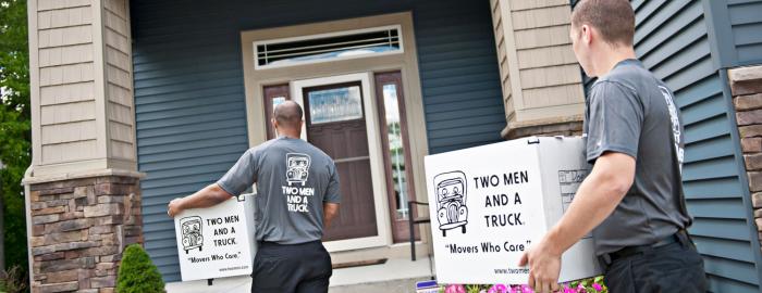 Movers carrying boxes into a home