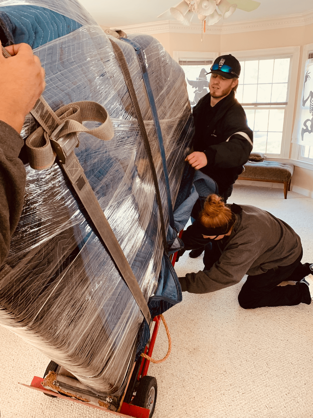 Mover strapping a piano to a piano board